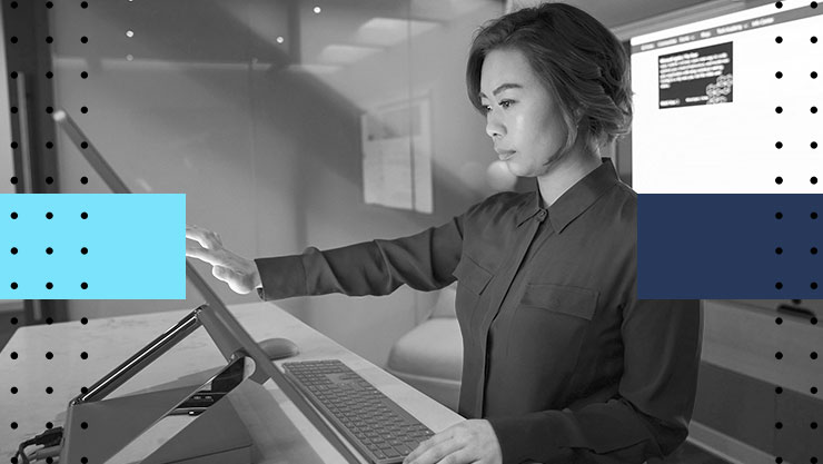 Stylized image of a woman working on a large touchscreen computer monitor