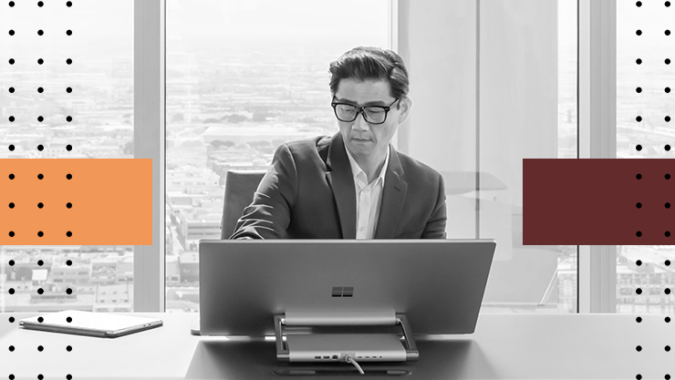 A man sitting at a desk looking at a computer monitor