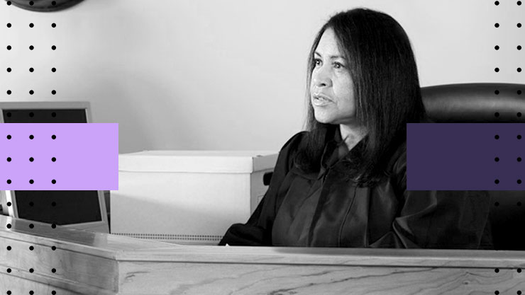 A judge sitting at her bench looking into the distance