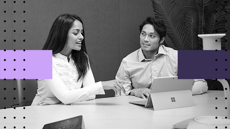Two people having a discussion in front of a laptop
