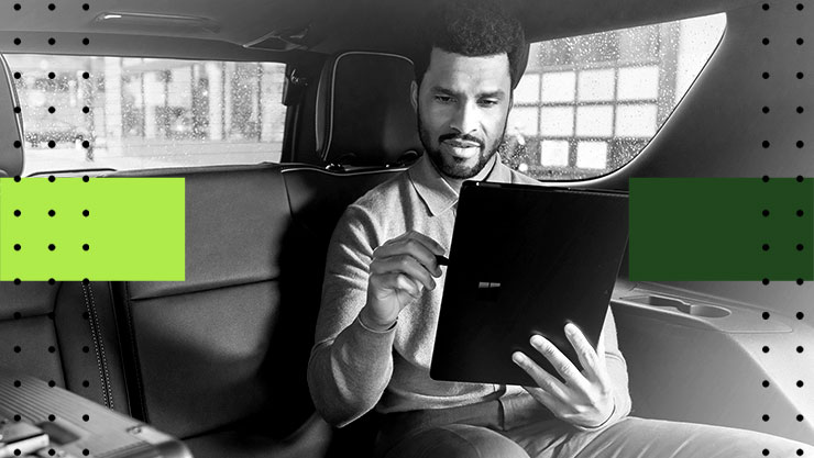 A man sitting in a car holding a tablet